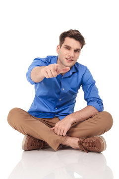 Young casual man pointing his finger at the camera.
