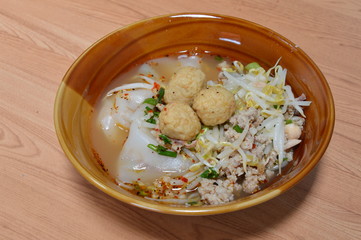 large rice noodle topping shrimp ball in soup