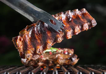 Fotobehang Delicious pork spareribs on grill grate © Lukas Gojda