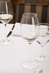 Restaurant dinner table with glass of wine