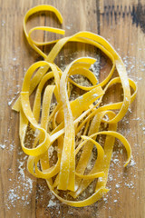 raw pasta with flour on brown background