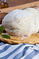 Pizza dough with ingredients on the wooden table