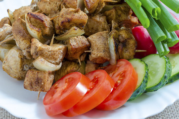 Mini skewers of chicken and a side dish of fresh vegetables
