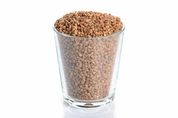 heap of buckwheat and glass isolated on white
