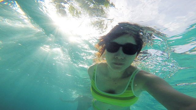 Woman swimming in pool with gopro camera