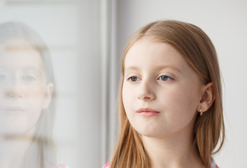 Little girl sitting on the windowsill