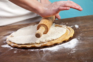 Making dough by mens hands on wooden table background