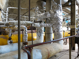 Old rusty industrial steel pipelines, valves and equipment at po