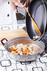 Chef putting stir fried Japanese pork curry to the pot