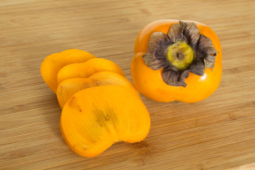 Kakifrüchte auf einem Holzbrett