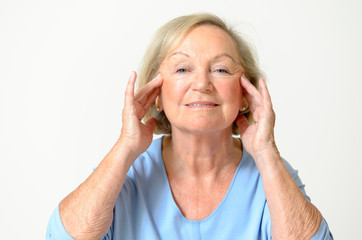 Seniorin zieht an ihrer Haut im Gesicht