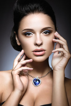 Beautiful brunette with a bright evening make-up with a necklace