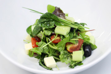 Delicious salad served in a white plate.