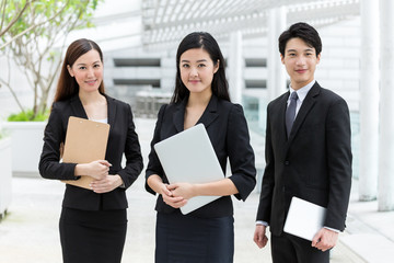Business teammate with holding laptop, tablet and clipboard
