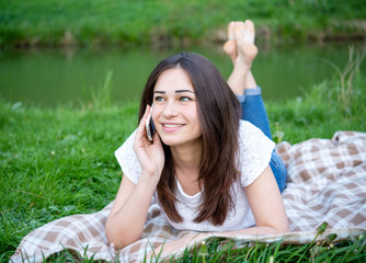 girl with a phone resting on the lawn