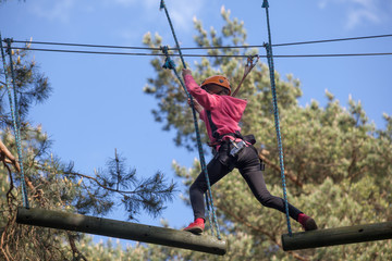 Girl climbing in adventure park , rope park     © wip-studio