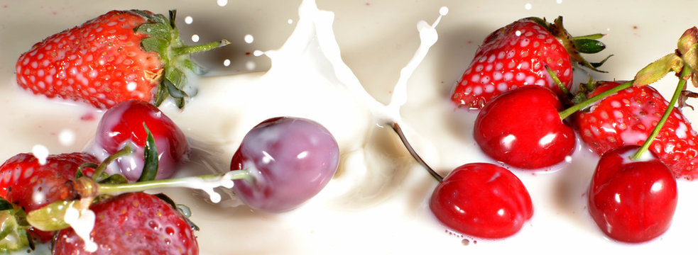 Strawberries and Cherries dropping into milk
