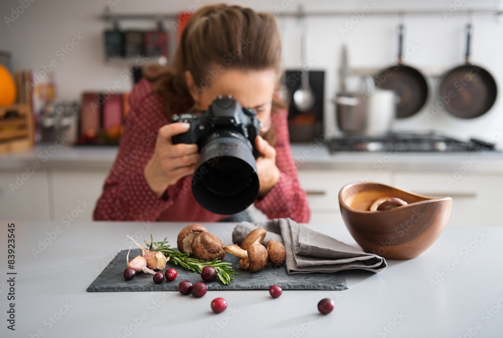 Wall mural woman food photographer taking closeup of mushrooms