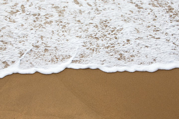 Sea foam on a sandy beach