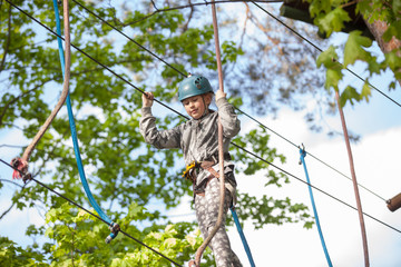 Girl climbing in adventure park , rope park  