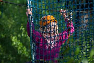 Girl climbing in adventure park , rope park  