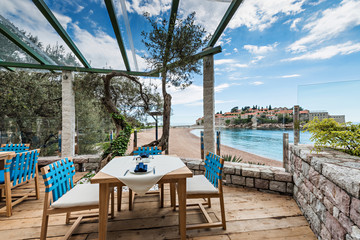 Tables at seaside restaurant with beautiful view on the island Saint Stephen in Montenegro