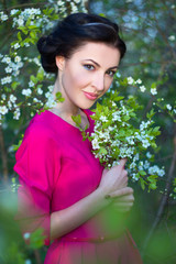 beautiful brunette woman in pink dress in blooming cherry tree g