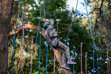  Girl climbing in adventure park , rope park 
