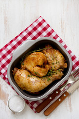 fried chicken with herbs in dish and fork with knife
