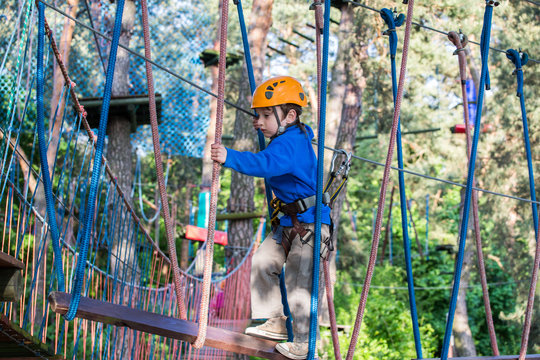 boy  climbing in adventure park,  rope park