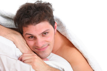 Fototapeta na wymiar happy handsome man lying in bed