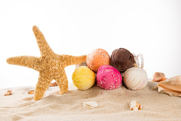 Ice cream scoops on sandy beach.