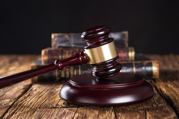 Wooden gavel and books on wooden table