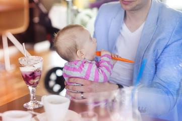 Young father with his cute baby daughter in cafe