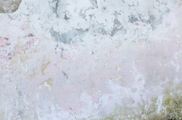 Cement wall with traces of crumbling plaster and moss.