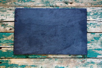 Top view of blackboard on rustic wooden background. 