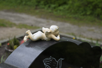 Engel liegt auf Grabstein