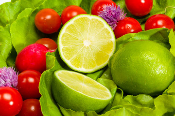 Fototapeta na wymiar Lettuce, radishes, chives, lime and tomatoes