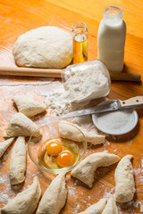 Fototapeta premium dough and flour with an egg, oil and a bottle of milk