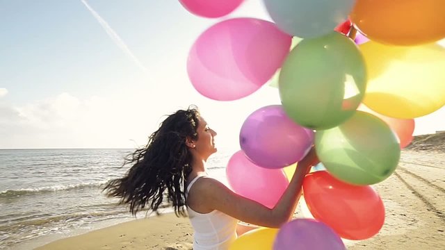 girl having fun on the beach with balloons