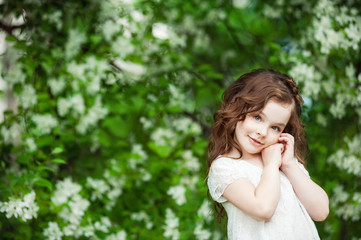 Fototapeta premium Portrait beautiful little girl near blossoming apple-tree