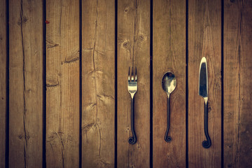 Vintage Cutlery - Fork, Spoon and Knife on Wood Background