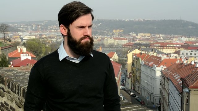 young handsome man with full-beard (hipster) disagree - city in background