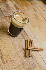 Cup of coffee and three cinnamon sticks