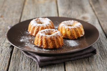 Bundt cakes on plate on grey wooden background