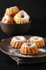 Bundt cakes on plate on black background