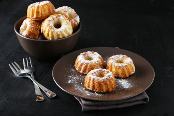 Bundt cakes on plate on black background
