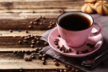 Cup of coffee with coffee beans on brown wooden background