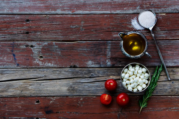 mozzarella cheese, tomatoes and spices on rustic wooden table. 