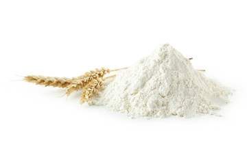 Heap of wheat flour with spikelets isolated on white
